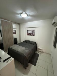 a bedroom with a bed in a room with a desk at Apartamento 2 Dormitórios, Bueno in Goiânia