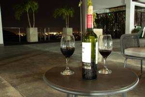 a bottle of wine sitting on a table with two glasses at Norte Cali - Bosque Living -203 in Cali
