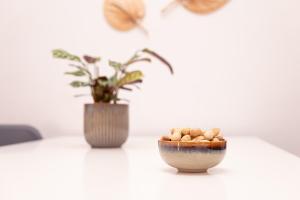 a bowl of peanuts sitting on a table with a vase at Nice Weekends Graz City Centre - Free Parking, Pets Welcome & Walk to Old Town - Mur - Kunsthaus in Graz +28 photos