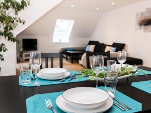 a dining room table with plates and wine glasses at Ferienwohnung Moorblick in Osten