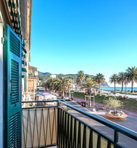a balcony with a view of the beach and palm trees at Your Sea Escape in Riva Trigoso