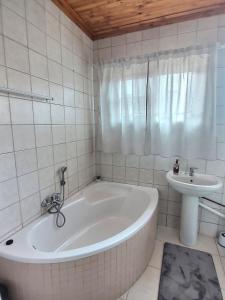 a white bathroom with a tub and a sink at Sea-Esta in Hentiesbaai