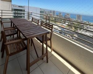 a wooden table and a chair on a balcony at Depto Boulevard del Sol II in Viña del Mar