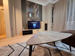 Una sala de estar con televisión y una mesa de café. en Botev Inn - R2, en Sofía 4 fotos más