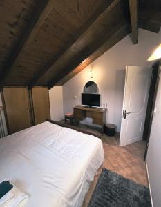 a bedroom with a white bed and a television at Tzovolos Apartments in Kalavrita