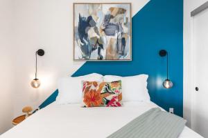a bedroom with a white bed with a blue wall at 2BD Modern DTLA Apartment Minutes from Dodger Stadium in Los Angeles
