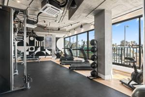a gym with treadmills and weights and a large window at 2BD Modern DTLA Apartment Minutes from Dodger Stadium in Los Angeles