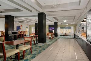 a restaurant with tables and chairs and a dining room at Holiday Inn Express & Suites Houston Northwest-Brookhollow by IHG in Houston