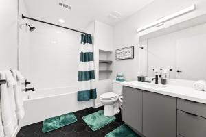 a bathroom with a tub and a toilet and a sink at 2BD Modern DTLA Apartment Minutes from Dodger Stadium in Los Angeles +31 photos