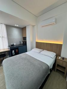 a bedroom with a large bed and a desk at Studio no centro, confortável e prático in Florianópolis