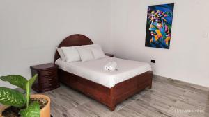 a bedroom with a bed and a painting on the wall at Alojamiento campestre Barbosa Santander in Barbosa