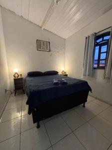 a bedroom with a bed in a room with a window at Primos Hostel & House in Búzios