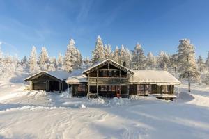 ein schneebedecktes Haus mit Bäumen im Hintergrund in der Unterkunft Moderne hytte plass for 10 in Rendalen