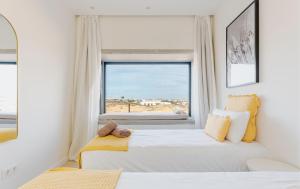 deux lits dans une chambre avec une fenêtre dans l'établissement Villa Calma by Aura Collection, à Lajares