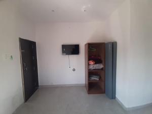 a room with a refrigerator and a wall at Hotel Randha and Lodging in Bhandardara 