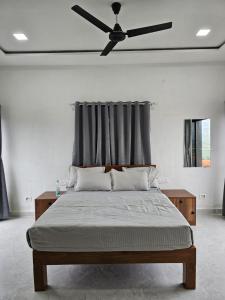 a bedroom with a bed with a ceiling fan at Hotel Randha and Lodging in Bhandardara 