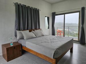 a bedroom with a bed and a large window at Hotel Randha and Lodging in Bhandardara 