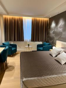 a bedroom with a large bed and blue chairs at Apartman 509 Zepterme -private host in Vrnjačka Banja