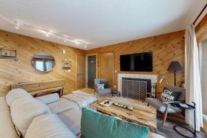 a living room with a couch and a fireplace at Snowshoe Condo in Bellaire