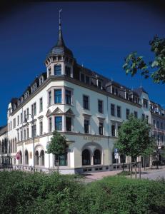 un grand bâtiment blanc avec une tour en haut dans l'établissement Hotel Kaiserhof, à Radeberg