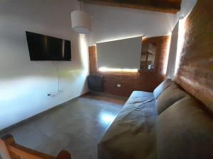 a living room with a couch and a flat screen tv at Acacias in El Bolsón