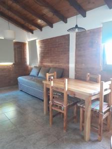 Una sala de estar con una mesa de madera y un sofá. en Acacias, en El Bolsón