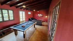 Una mesa de ping pong en una habitación con paredes rojas. en Casa Quinta la PAVA GRADE, en Chascomús 11 fotos más