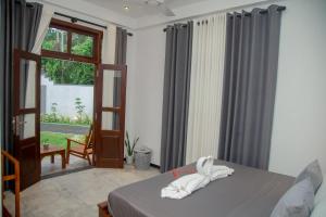 a bedroom with a bed and a sliding glass door at Villa White Elephant in Hikkaduwa +20 photos