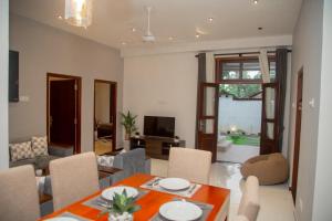 a living room with a table and chairs and a television at Villa White Elephant in Hikkaduwa