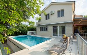 a swimming pool in front of a house at Villa Ana-Marija in Imotski