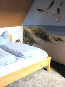a bedroom with a bed with birds flying over the beach at Ferienwohnung Zawalla in Kamminke