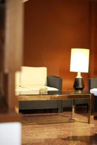 a living room filled with furniture and a lamp at Hotel Al Posta in Casarsa della Delizia