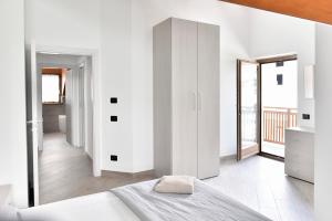 biała sypialnia z łóżkiem i dużym lustrem w obiekcie La Pieve Apartments w mieście San Lorenzo in Banale +37 zdjęć