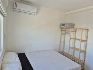 a small room with a bed and a book shelf at Casa no Paraíso Praia do Frances in Marechal Deodoro