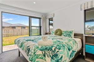 ein Schlafzimmer mit einem Bett und einem großen Fenster in der Unterkunft Puna Rise - Taupo Holiday Home in Taupo