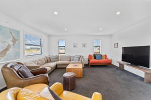 ein Wohnzimmer mit Sofas und einem Flachbildfernseher in der Unterkunft Puna Rise - Taupo Holiday Home in Taupo