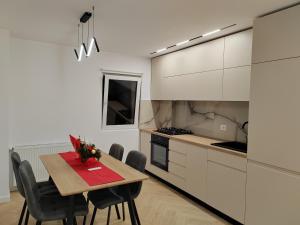 a kitchen with a table and chairs in a room at Central Residence Câmpulung in Câmpulung