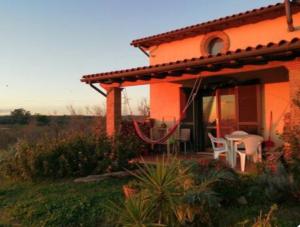 una casa con una mesa y sillas en un patio en Namaste, mare, lago e terme di Vulci, en Canino