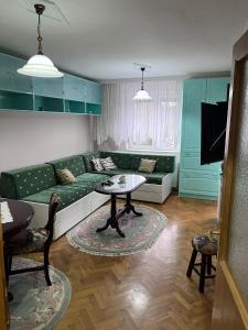 a living room with a green couch and a table at Apartman Ivanka in Zlatibor