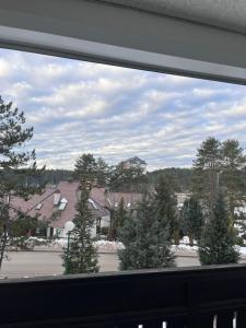 a window view of a parking lot with christmas trees at Apartman Ivanka in Zlatibor