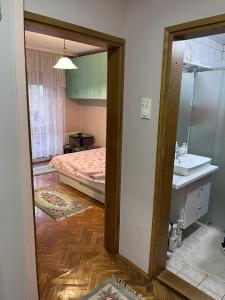 a room with a bed and a sink and a mirror at Apartman Ivanka in Zlatibor