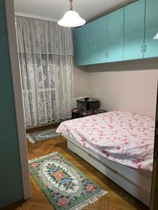 a bedroom with a bed and blue cabinets and a rug at Apartman Ivanka in Zlatibor +4 photos