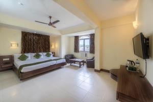 a bedroom with a bed and a flat screen tv at Treebo Trend Green Park in Mapusa