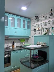a kitchen with blue cabinets and a table in it at Apartman Ivanka in Zlatibor