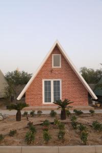 ein Backsteinhaus mit zwei Bäumen davor in der Unterkunft Malina Resort منتجع مالينا in Ras al Khaimah