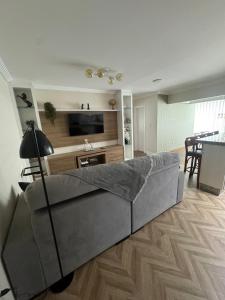 a living room with a couch and a television at Apartamento na Praia do Perequê in Porto Belo