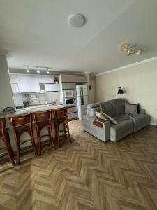 a living room with a couch and a kitchen at Apartamento na Praia do Perequê in Porto Belo