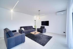 a living room with two blue couches and a tv at Villa Laura in Funtana