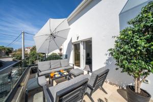 a patio with a table and chairs and an umbrella at Apartment Coral in Brodarica
