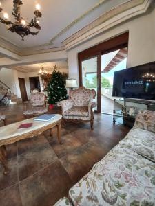 a living room with a christmas tree and a tv at Salty Sea Breeze in Artemida